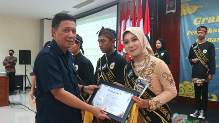 Direktur UT Bandung, Drs. Enceng, M.Si. saat menyerahkan sertifikat juara kepada Duta Putri Kampus UT Bandung 2022